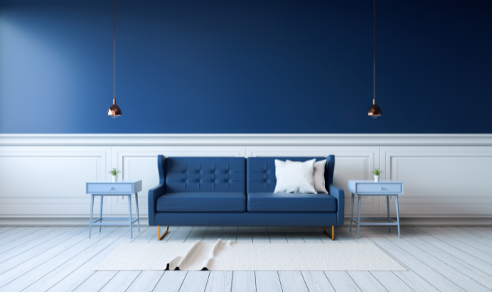 Cozy living room with blue walls, blue sofa, and decorative pillows